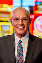 Headshot of Randy Taylor on a brightly colors casino background